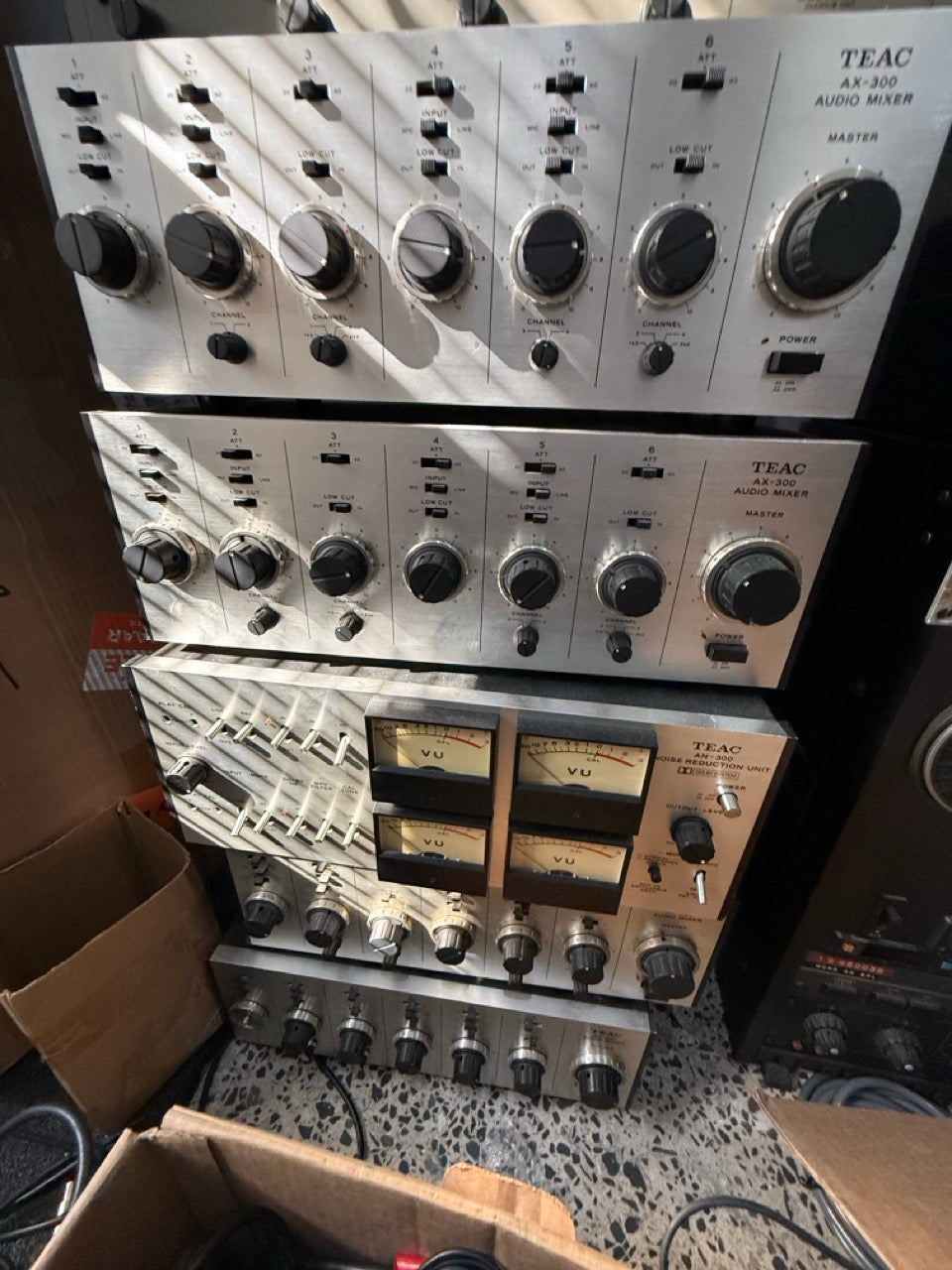 TEAC AN-300 noise reduction unit with its four VU meters, sitting below two matching TEAC AX-300 audio mixers from the same 1970s set