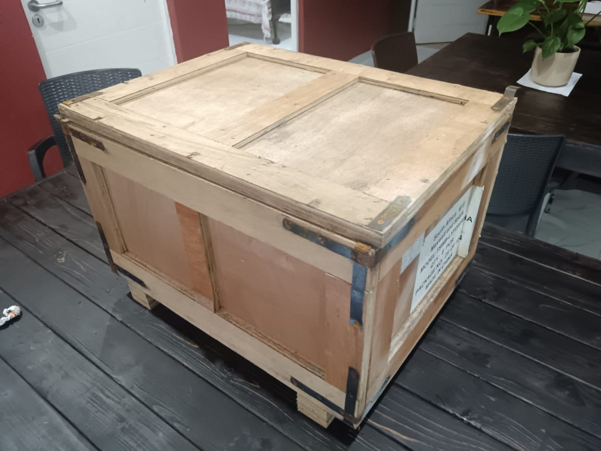 A plywood shipping crate on a pallet base with steel corner brackets, the packing standard heavy vintage studio gear needs for international freight